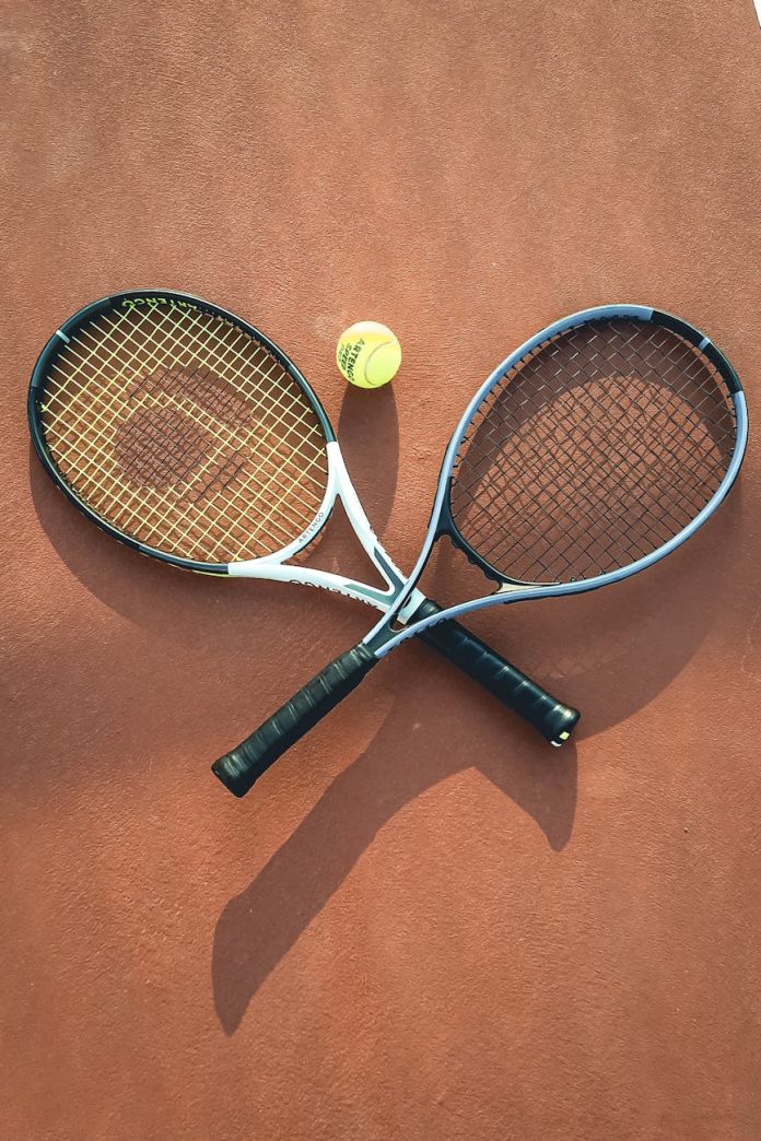 tennis rackets with ball on court